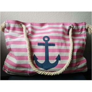 Ein rosa-weiß gestreifter Stockschirm „Maritim“ Anker Streifen Regenschirm mit einem großen blauen Ankermotiv, das dem Anker-Logo auf der Vorderseite ähnelt. Die Tasche hat dicke, gedrehte Seilgriffe, die an silbernen Ösen befestigt sind. Der Hintergrund ist eine helle Wand.