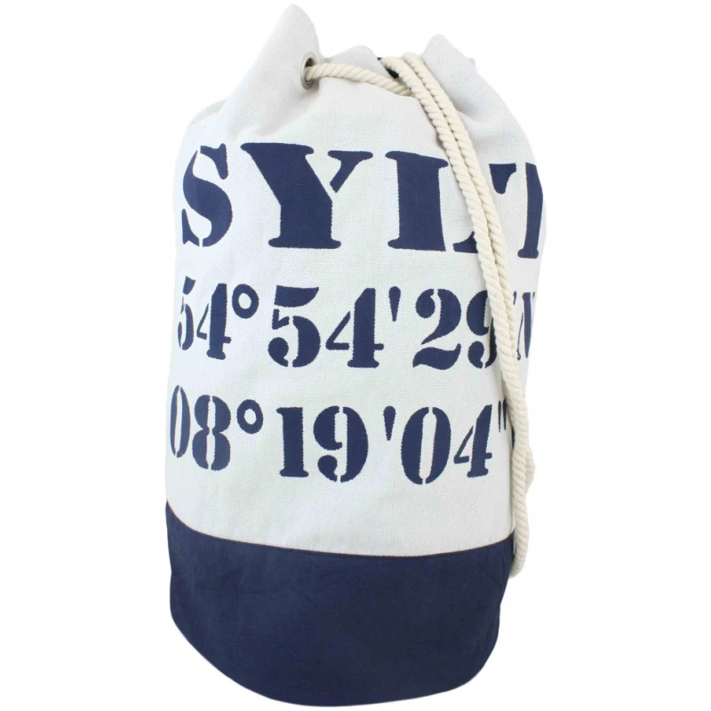 Eine XS Shopper "kleine Krabbe" Tasche Maritim Streifen mit dem Wort "SYLT" in großen marineblauen Buchstaben über den geografischen Koordinaten "54°54'29" und "08°19'04". Der untere Teil der Tasche ist ebenfalls marineblau. Eine weiße Kordel dient als Kordelzug.