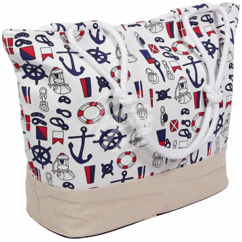 Eine weiße Einkaufstasche „Strandtasche Weiss Maritim“ mit nautisch inspirierten Aufdrucken, darunter Anker, Segelboote, Rettungsringe und Flaggen in Blau und Rot. Die Tasche hat stabile weiße Seilgriffe und einen beigen Boden.