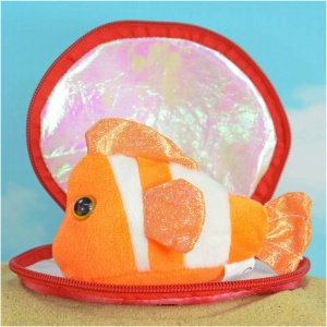 Ein Plüsch-Clownfisch mit glitzernden orange-weißen Streifen liegt in einer offenen Muschelschale. Die Muschelschale ist außen rot und innen glänzend und schillernd. Der Hintergrund zeigt einen hellblauen Himmel mit vereinzelten weißen Wolken, der die perfekte Kulisse für diese entzückenden Meerestiere aus Plüsch in der Muschel, Seepferd, Clownfisch und Schildkröte - 13 cm - bildet.