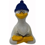 Eine kleine Skulptur einer Ente mit verschränkten Armen, weiß bemalt mit gelbem Schnabel und Flossen. Die Poly Yoga Möwe mit Mütze erinnert an eine fröhliche Möwe, trägt eine strukturierte blaue Beanie und hat große Augen und ein breites Lächeln. Der Hintergrund ist schlicht weiß.