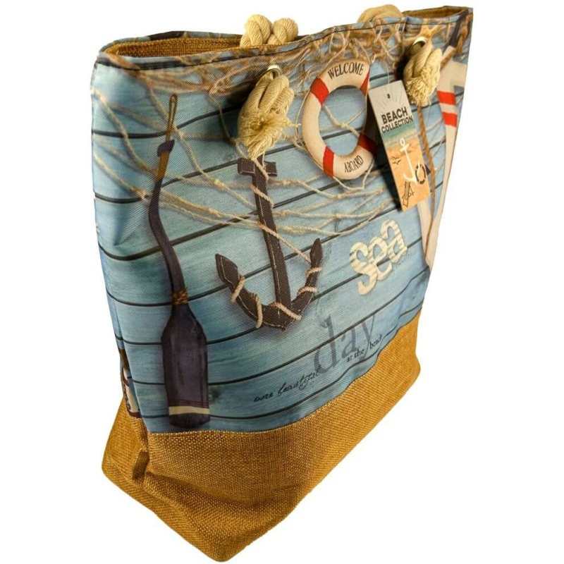 Eine blau-braune Einkaufstasche „Strandtasche Maritim Anker“ ca. 50 x 38 x 17 cm, mit Motiven im nautischen Stil, darunter ein Anker, ein Rettungsring, ein Paddel und die Worte „Sea“ und „Relax“. Die Tasche hat Seilgriffe und an einem Griff hängt ein kleines „Beach Collection“-Etikett.