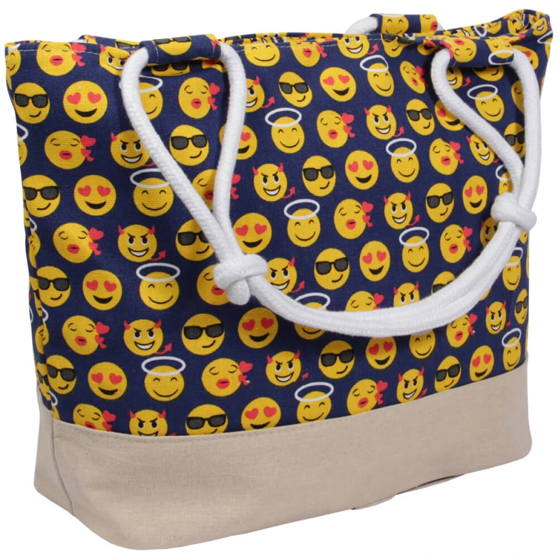 Eine farbenfrohe Einkaufstasche Strandtasche blau Emoticon ca. 48 cm x 35 cm mit einem Muster aus verschiedenen gelben Emojis, darunter welche mit Sonnenbrillen, Heiligenscheinen, Herzen und verschiedenen Ausdrücken auf dunkelblauem Hintergrund. Die Tasche hat einen beigen Boden und weiße Seilgriffe.