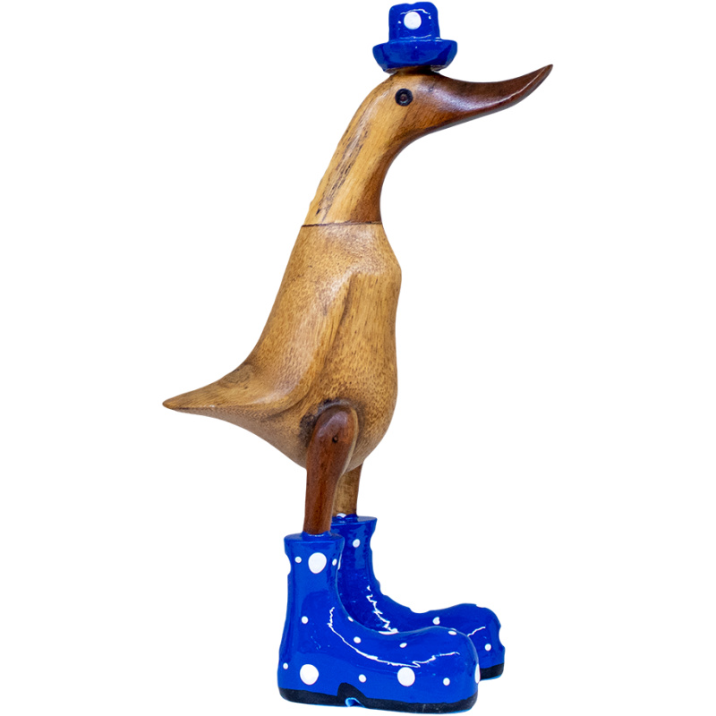 Eine aufrecht stehende Entenskulptur aus Holz trägt einen kleinen blauen Hut und blaue Stiefel mit weißen Punkten. Die Ente hat eine glatte Oberfläche und ein skurriles Aussehen.