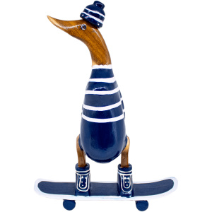 Das Bild zeigt die „Ente auf Skateboard aus Bambus blau/weiss ca 21×10 cm Höhe 28 cm“, eine Bambus-Entenfigur in einem blau-weiß gestreiften Outfit, einer Beanie und Stiefeln, die auf einem Skateboard steht. Die Figur ist sorgfältig geschnitzt und bemalt, sodass sie einer Ente ähnelt.