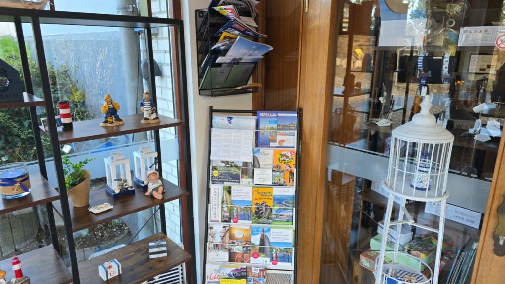 Vitrine mit Souvenirs, Postkarten und Informationsmaterial in einem Geschäft. Bietet eine Vielzahl von Andenken und touristischen Informationen.